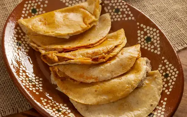 Tacos de canasta clásicos en tortilla del 14 servidos en plato de barro